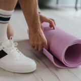 Persoană care urcă scările unei clădiri de birouri în loc să folosească liftul, cu geanta pe umăr